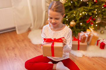 Image showing smiling girl with christmas gift at home