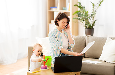 Image showing working mother with baby calling on smartphone