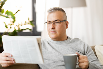 Image showing man reading newspaper and drinking coffee at home