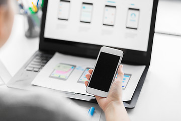 Image showing web designer with smartphone and laptop at office