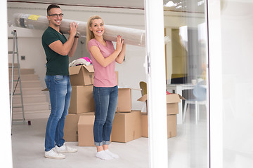 Image showing couple carrying a carpet moving in to new home