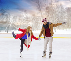 Image showing happy couple holding hands on outdoor skating rink