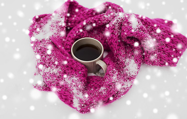 Image showing tea or coffee mug and winter scarf on snow