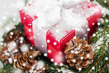 Image showing close up of christmas gift and fir wreath on snow