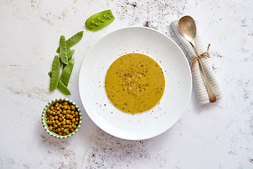 Image showing Creamy soup with green pea in a ceramic white plate