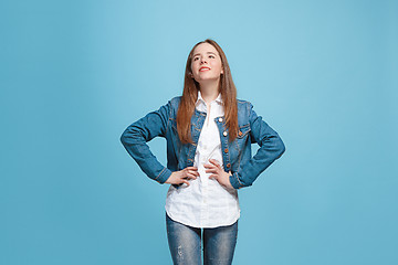 Image showing The happy teen girl standing and smiling against blue background.