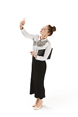 Image showing Full length portrait of a smiling female teacher holding a folder isolated against white background