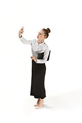 Image showing Full length portrait of a smiling female teacher holding a folder isolated against white background