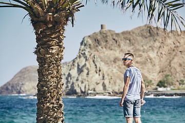 Image showing Man with sunglasses in shadow of palm tree