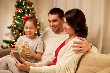 Image showing family with smartphone at home on christmas