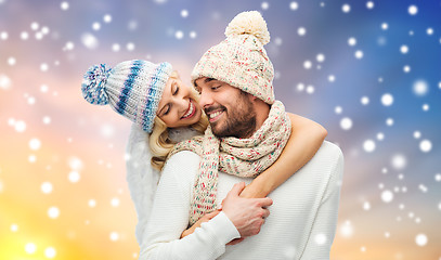 Image showing happy couple in winter clothes hugging over snow