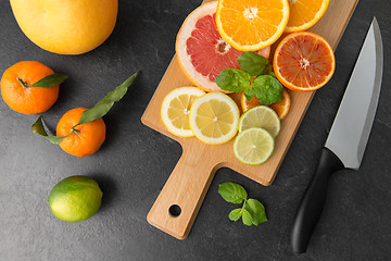 Image showing close up of fruits and knife on slate table top