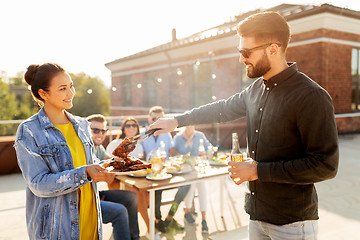 Image showing happy friends at barbecue party on rooftop