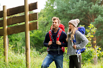 Image showing couple of travelers with backpacks at signpost