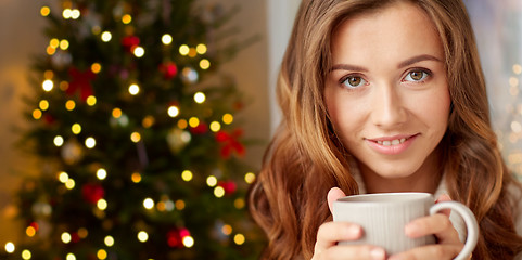 Image showing happy woman with cup of tea or coffee on christmas