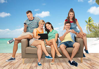 Image showing friends with tablet pc and smartphones over beach