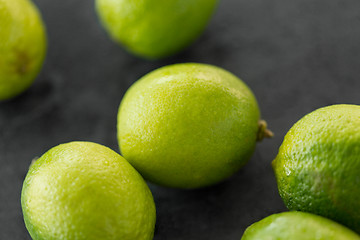 Image showing close up of whole limes on slate table top