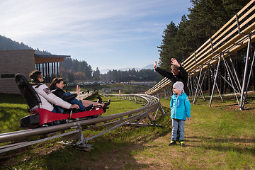 Image showing Happy family driving on alpine coaster