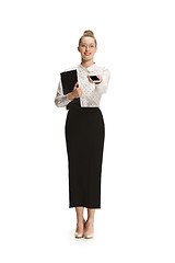 Image showing Full length portrait of a smiling female teacher holding a folder isolated against white background