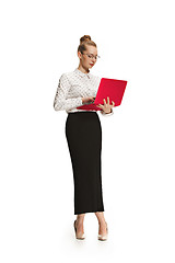 Image showing Full length portrait of a smiling female teacher holding a laptop isolated against white background