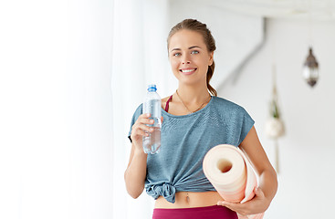 Image showing woman with bottle of water and mat at yoga studio