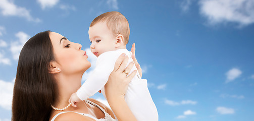 Image showing mother kissing baby over sky background