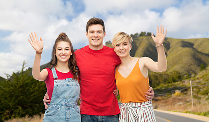 Image showing happy friends hugging over big sur hills and road