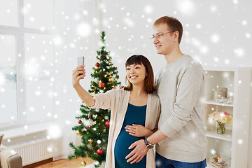 Image showing happy family couple taking selfie at christmas