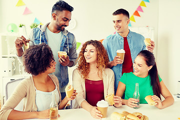 Image showing happy friends or team eating at office party