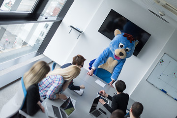 Image showing boss dresed as bear having fun with business people in trendy of