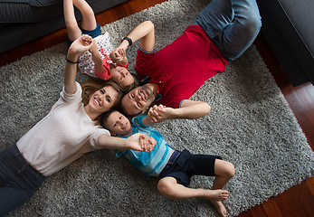 Image showing happy family lying on the floor