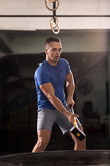 Image showing man workout with hammer and tractor tire