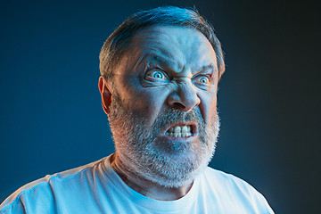 Image showing The senior emotional angry man screaming on blue studio background