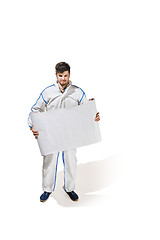 Image showing Young male decorator painting with a poster climbed a ladder isolated on white background.