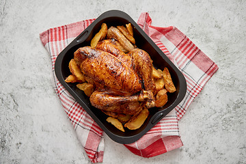 Image showing Roasted chicken or turkey with potatoes in black steel mold