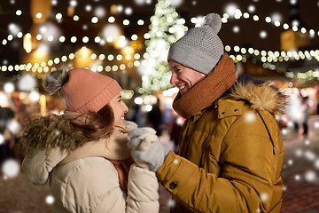 Image showing happy couple holding hands at christmas tree