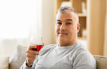 Image showing man drinking red wine from glass at home