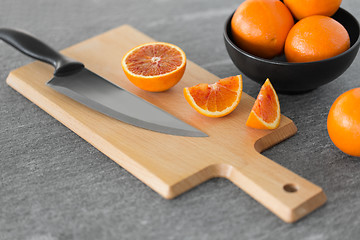 Image showing close up of oranges and knife on cutting board