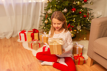 Image showing smiling girl with christmas gift at home