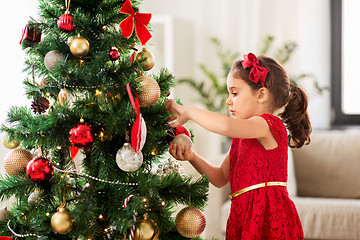 Image showing little girl decorating christmas tree at home