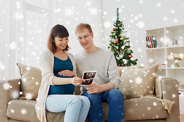 Image showing happy couple with ultrasound images at christmas