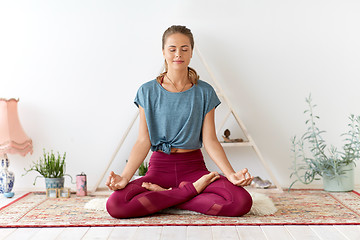 Image showing woman meditating in lotus pose at yoga studio
