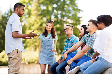 Image showing happy international friends talking in park