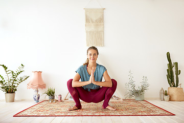 Image showing young woman doing garland pose at yoga studio