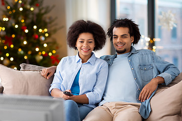 Image showing happy couple watching tv at home on christmas
