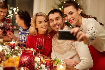 Image showing friends having christmas dinner and taking selfie