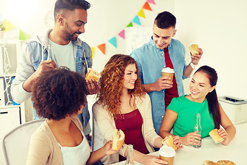 Image showing happy friends or team eating at office party