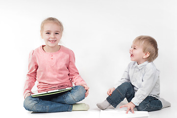 Image showing Girl uses tablet and boy playing with chalk