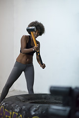 Image showing black woman workout with hammer and tractor tire