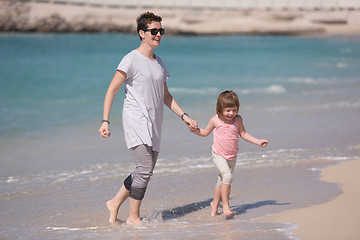 Image showing mother and daughter running on the beach